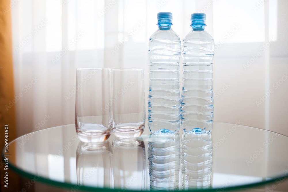 Two bottles and two glasses on the table. Two bottles and two glasses on the table.