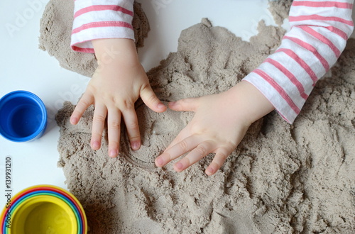 Little baby girl age of 1,11 years play with kinetic sand