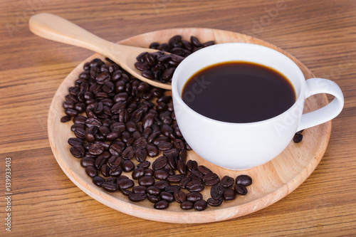 Coffee cup and beans on wooden background