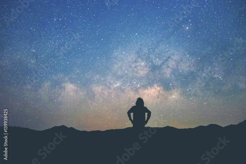 Long exposure Man standing along the waters edge under the Milky Way galaxy
