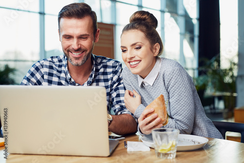 Couple working on laptop at restaurant, cafe during lunch
