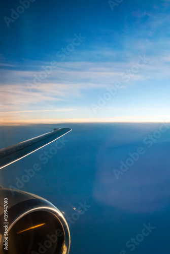 View of the sunrise and the clouds from within, out of the plane