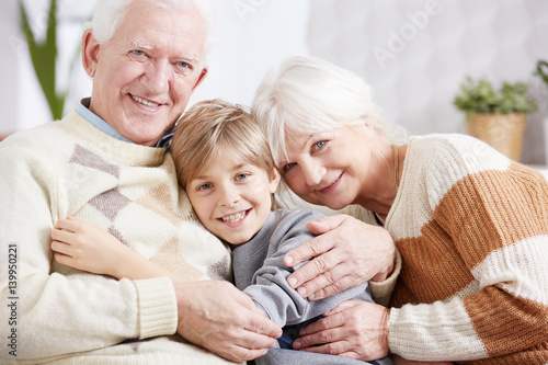 Grandparents embracing their grandson