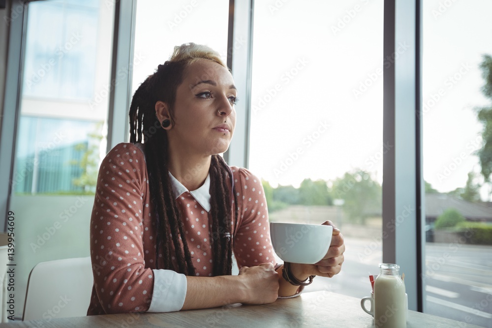 Thoughtful woman having cup of coffee Thoughtful woman having cup of coffee