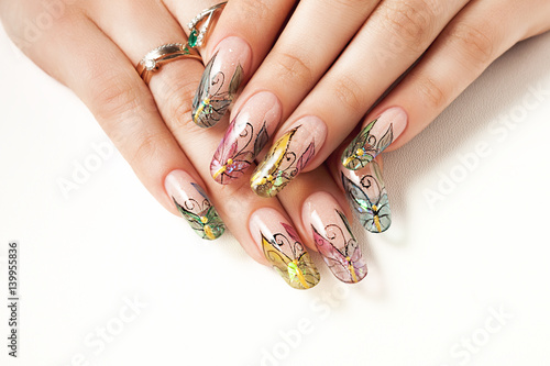 Summer manicure with a butterfly pattern.