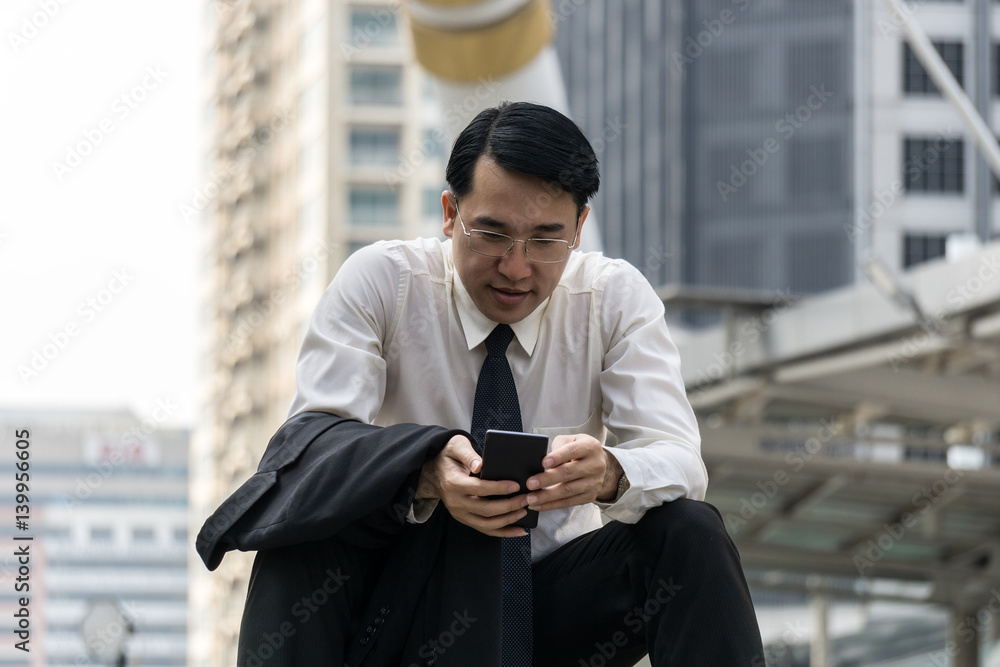 Businessman using smartphone at outdoor of the office building Businessman using smartphone at outdoor of the office building