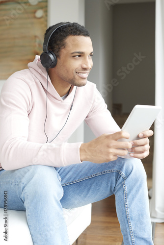 Enjoy the music. Afro American young man listening music on his laptop