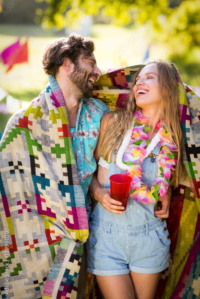Couple wrap themselves in blanket Couple wrap themselves in blanket