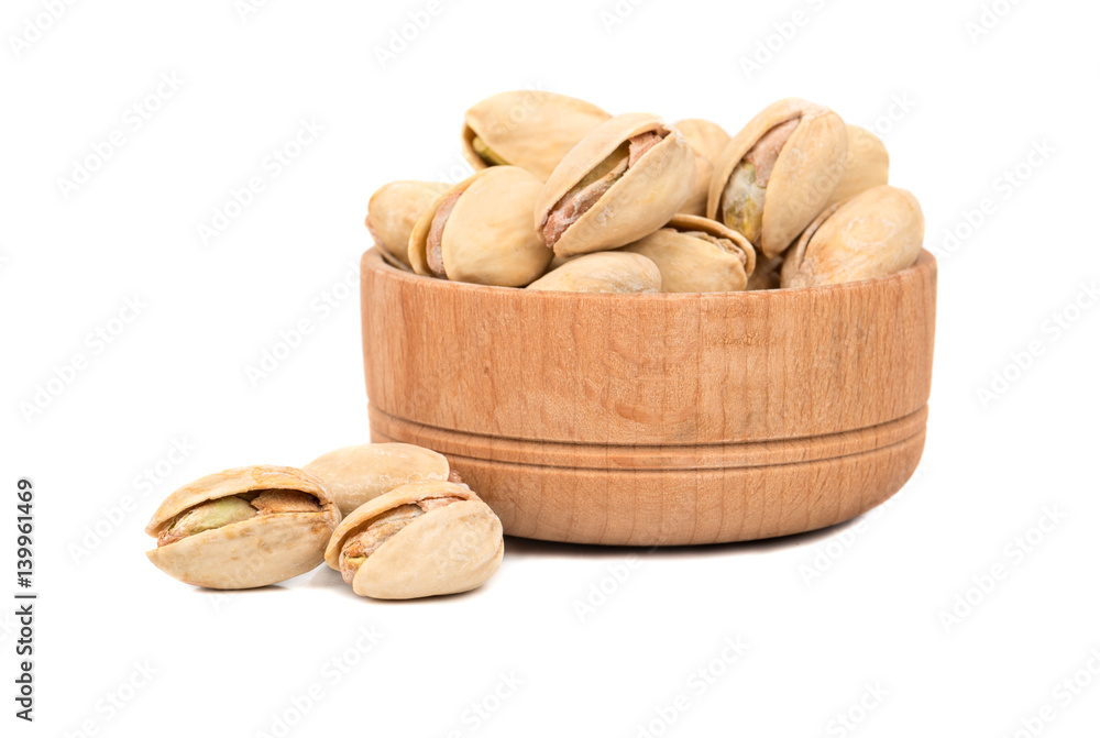 Pistachio nuts in a wooden bowl on a white background Pistachio nuts in a wooden bowl on a white background
