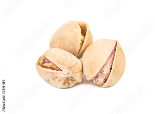 Three salted pistachio nuts on white background