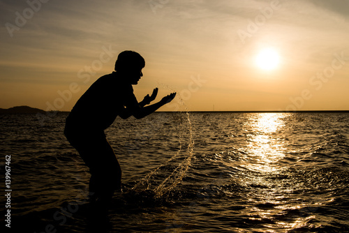 Quadro su tela Silhouette of young playing in the river.