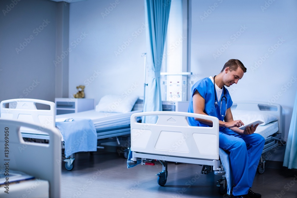 Doctor using digital tablet in ward Doctor using digital tablet in ward