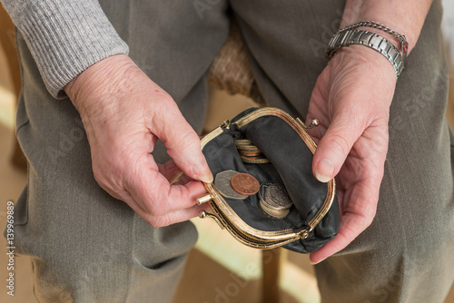 Hands of a pensioner checking loose change in purse