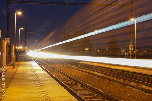 Train with strong light on long exposure in station at night scene.
