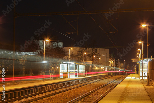Train shoot from back with red light on long exposure in station at night scene.