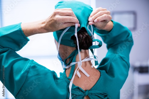 Rear view of female surgeon wearing surgical mask