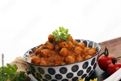 Chana Masala indian dish spicy Chick Peas also known as Chola Masala or Chole served in a white bowl