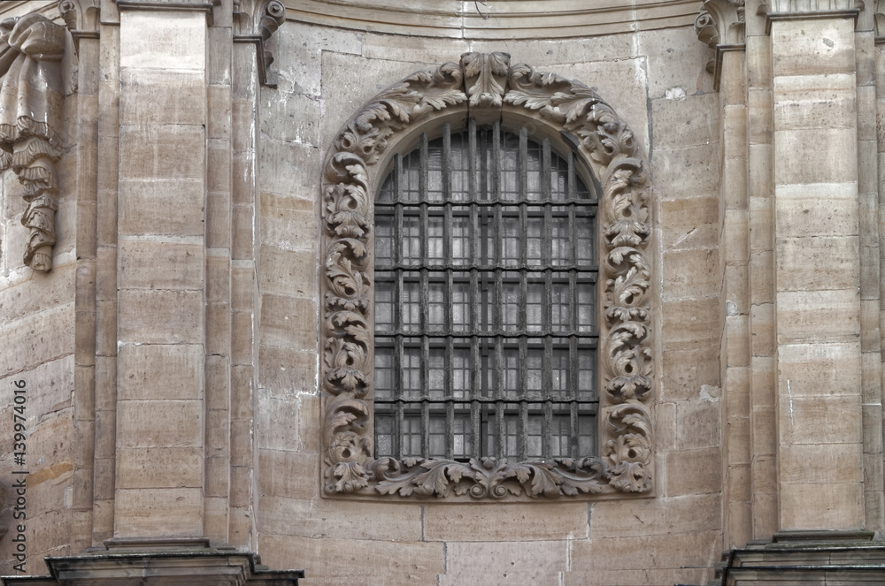 Beautiful ornamental old window in the wall of the church