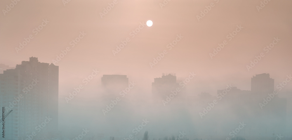 Fog over the city.  Dense fog envelops the residential area. Buildings sticking out of the fog.