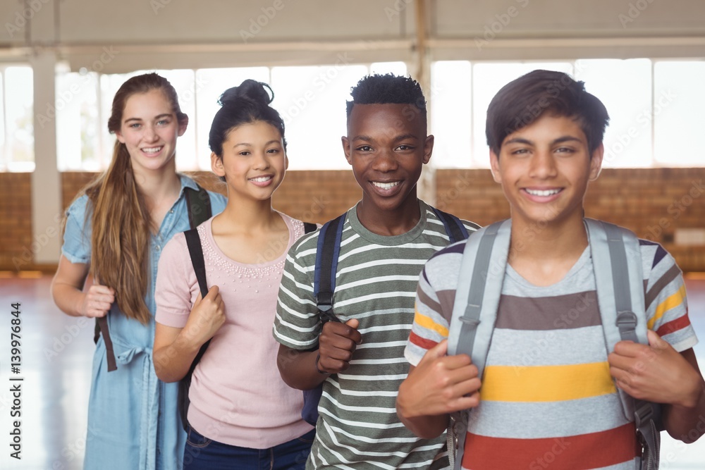 Portrait of happy students standing with schoolbags in campus Portrait of happy students standing with schoolbags in campus