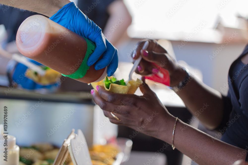 Chef pouring sauce onto customers food Chef pouring sauce onto customers food