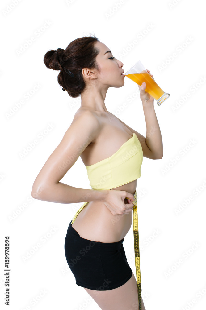 Asian young woman slim fit is Drink orange juice and measuring waist on white Studio Background Asian young woman slim fit is Drink orange juice and measuring waist on white Studio Background