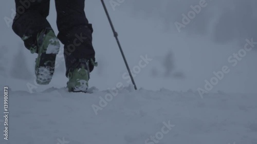 Hiking in winter snow at dawn with ski boots (slow motion)
