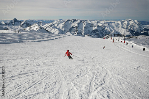 Girl skier making large turns in snowy mountains