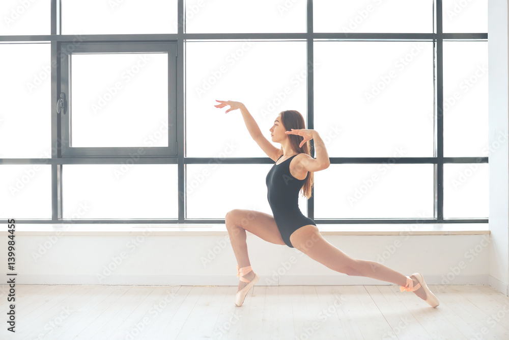 Obraz premium Beautiful young athletic woman dancer at a training session. Ballerina. Preparing for the competition.