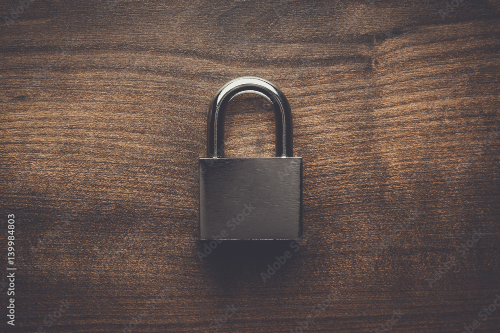 Naklejka premium check-lock on the brown wooden table background