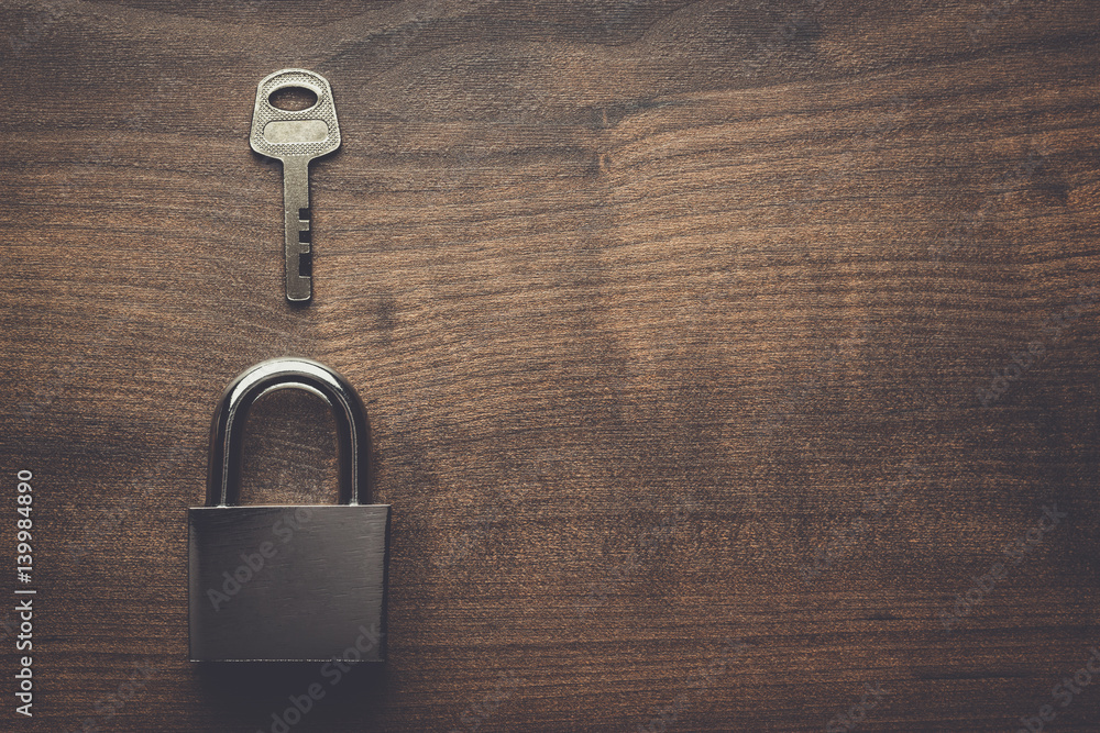 Fototapeta premium check-lock and key on the brown wooden table background