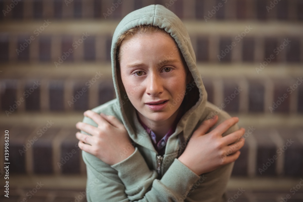 Portrait of sad schoolgirl sitting alone on staircase Portrait of sad schoolgirl sitting alone on staircase