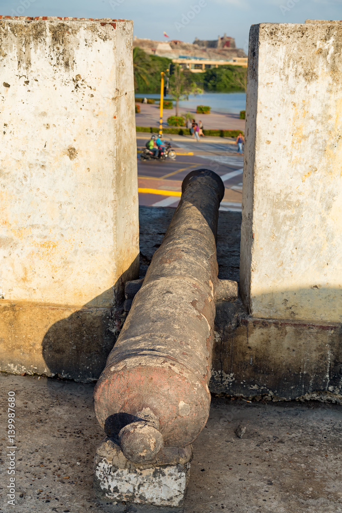 View of an antique cannon and a turret with Castillo de San Felipe de Barajas in Cartagena, Colombia.