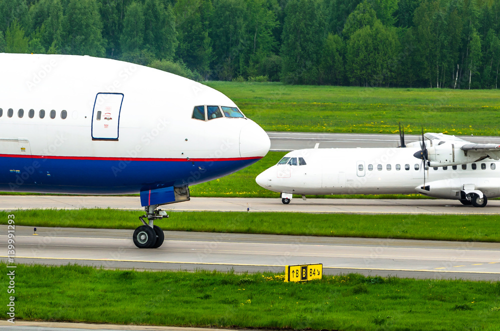 Two planes are big and small. Noses of aircraft at the airport Two planes are big and small. Noses of aircraft at the airport