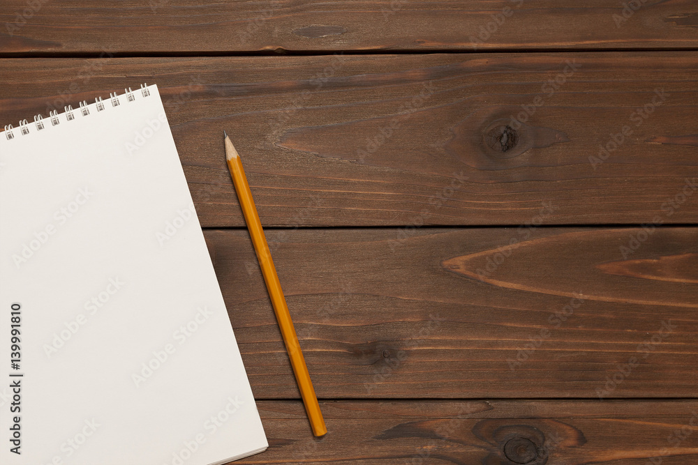 notebook and pencil on wooden background notebook and pencil on wooden background