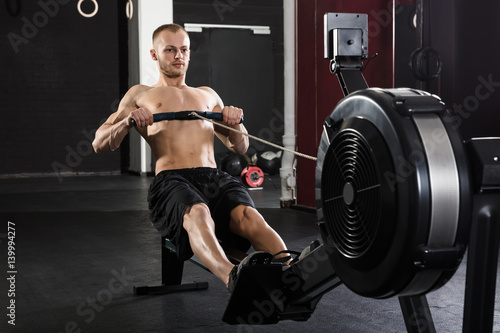 Young Man Exercising With Row Machine