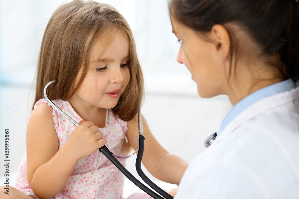Happy little girl at  health exam at doctor office. Medicine and health care concept