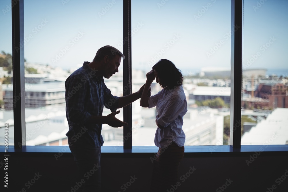 Couple arguing near the window Couple arguing near the window