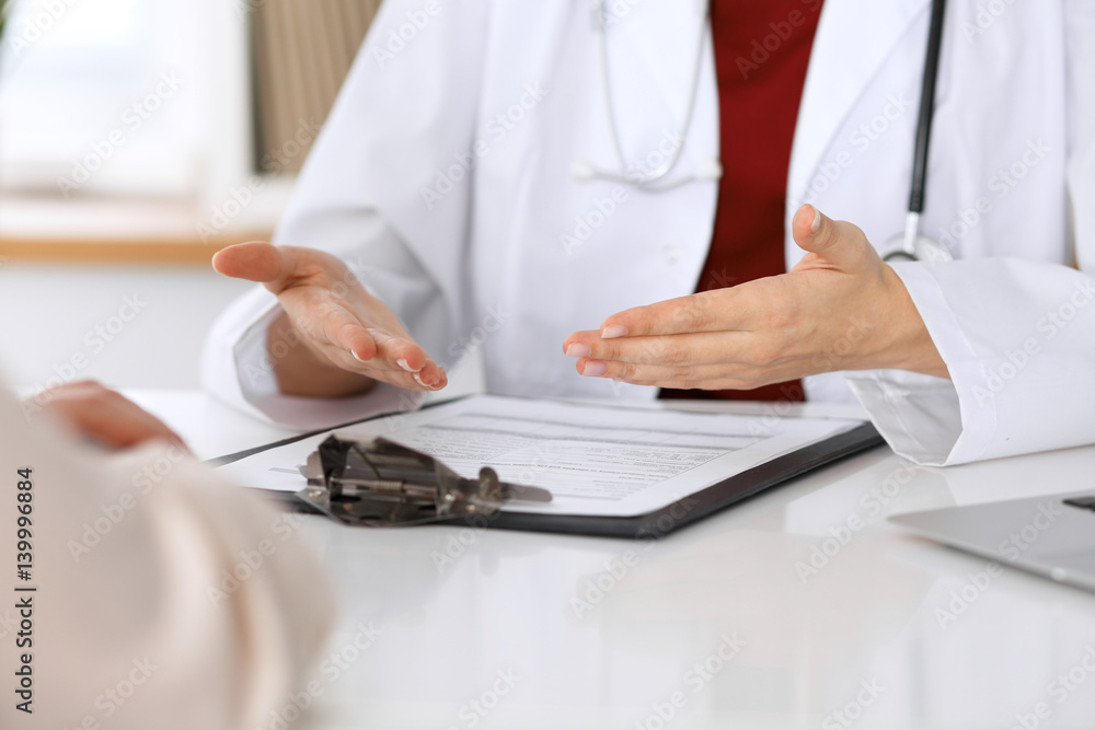Close up of a doctor and patient hands while discussing medical records after health examination Close up of a doctor and patient hands while discussing medical records after health examination