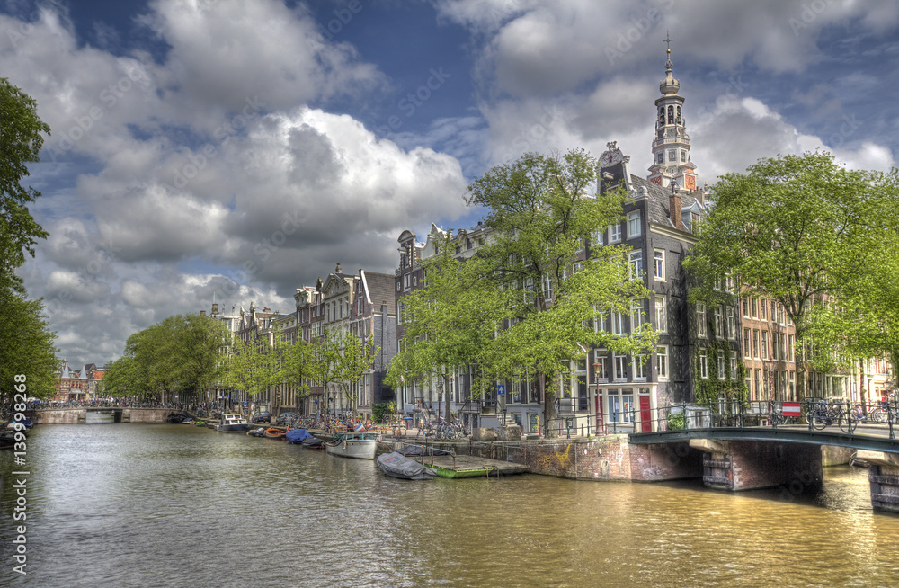 Canal with trees and historical buildings in Amsterdam