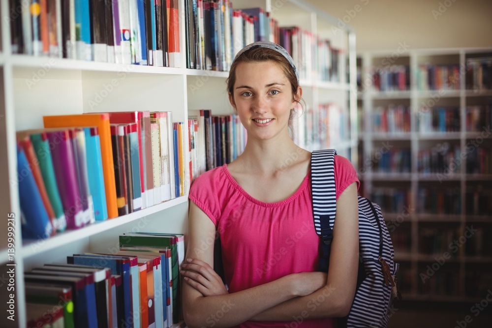 schoolgirl standing with arms crossed in library schoolgirl standing with arms crossed in library