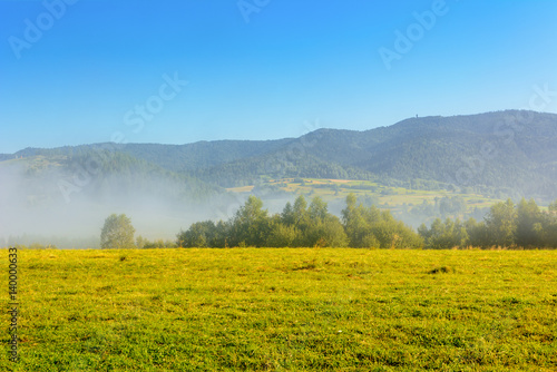 Misty morning rural landscape of a fields in summer. Pieniny mountains. Poland.