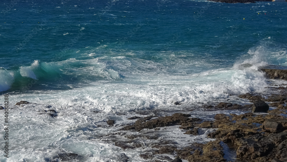 Ocean waves on the black rocky coastline in Canarias