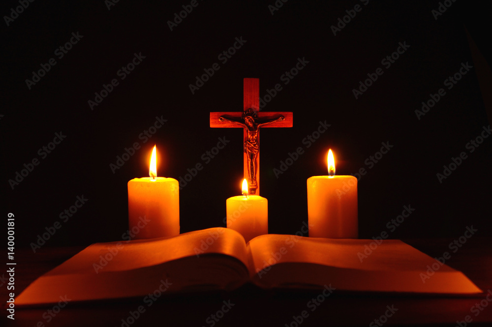 Crucifix and three burning candles with open bible on table in the darkness. Pray to Jesus Christ. Hope on good life. 4