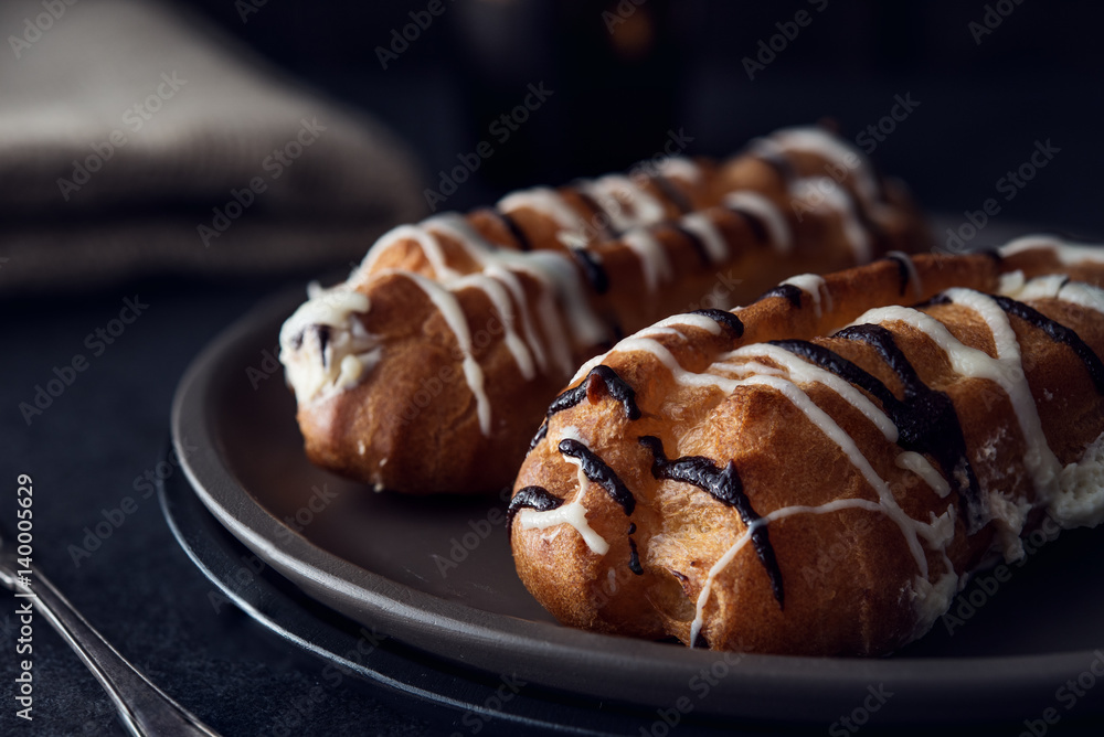 Sweet eclair dessert on black background Sweet eclair dessert on black background
