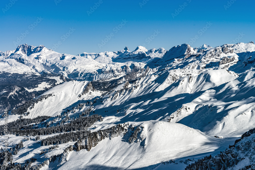 Beautiful mountains in snow. Evening aerial view with shadows.