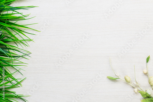 Easter spring colorful eggs and green grass lying on white wooden table background