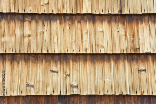 Wall of the building shingle with boards.  Wooden lining of a building wall with stains.