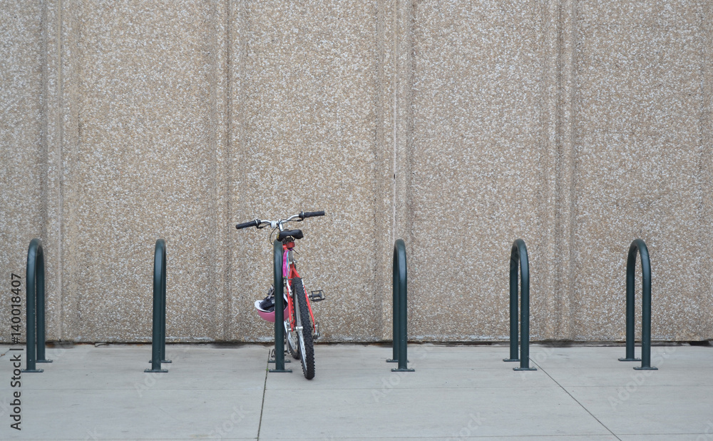 Αυτοκόλλητο Red bike in rack in front of concrete wall