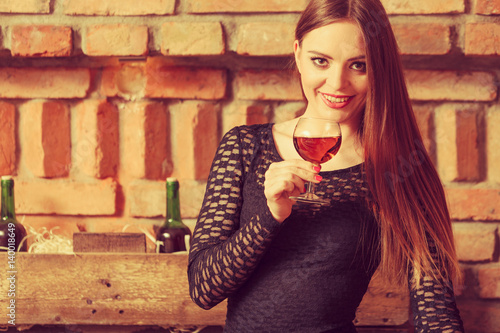 Woman tasting wine in rural cottage interior